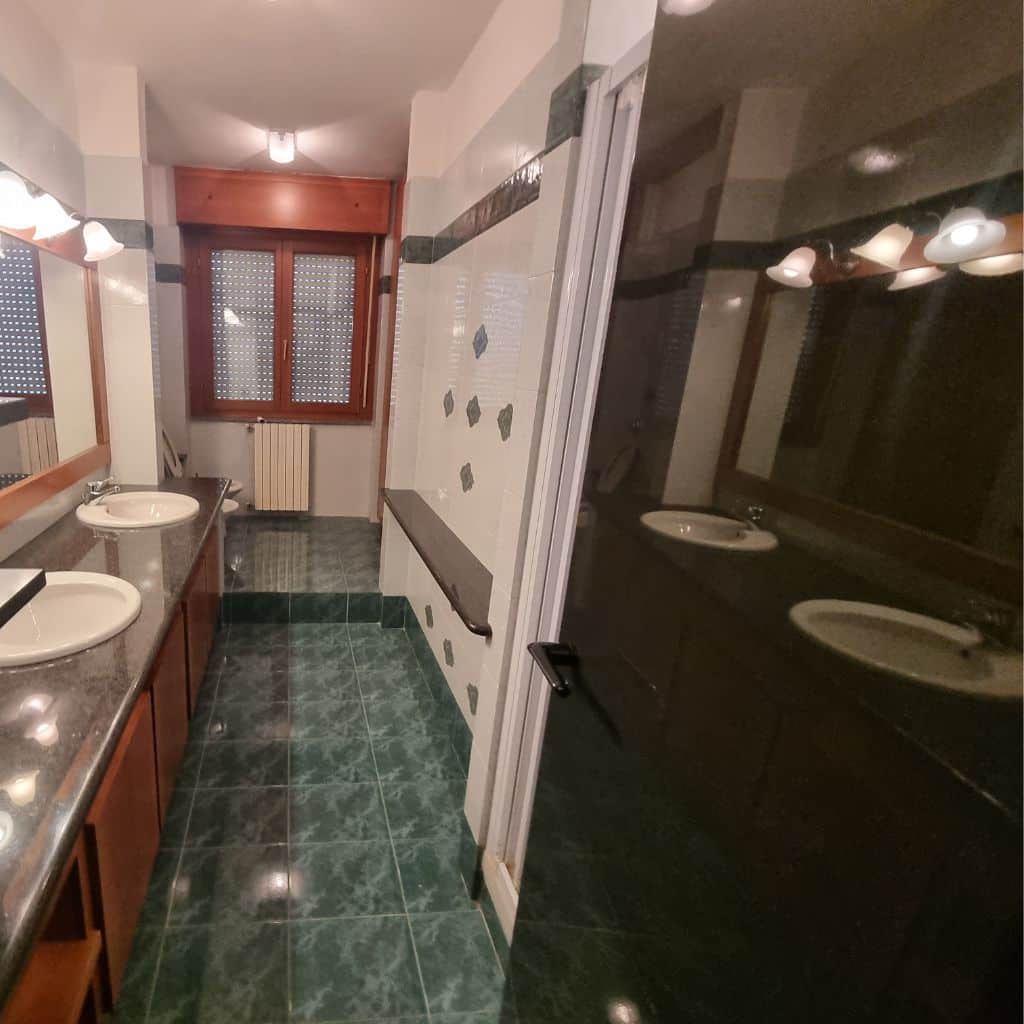 Bagno prima (piastrelle verdi, specchio con cornice legno, sanitari tradizionali)