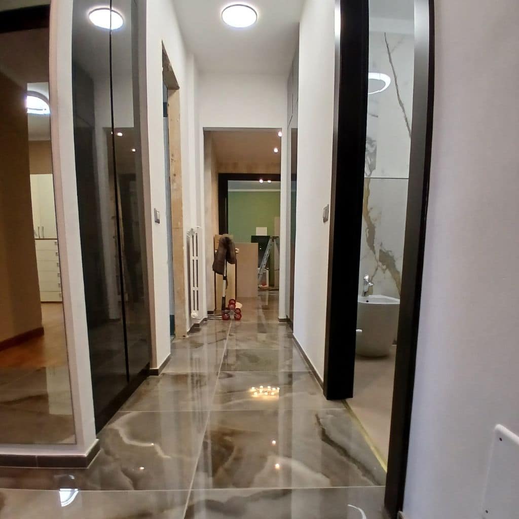 Disimpegno dopo (gres effetto marmo, porte nere, luce a soffitto, finiture bianche moderne)