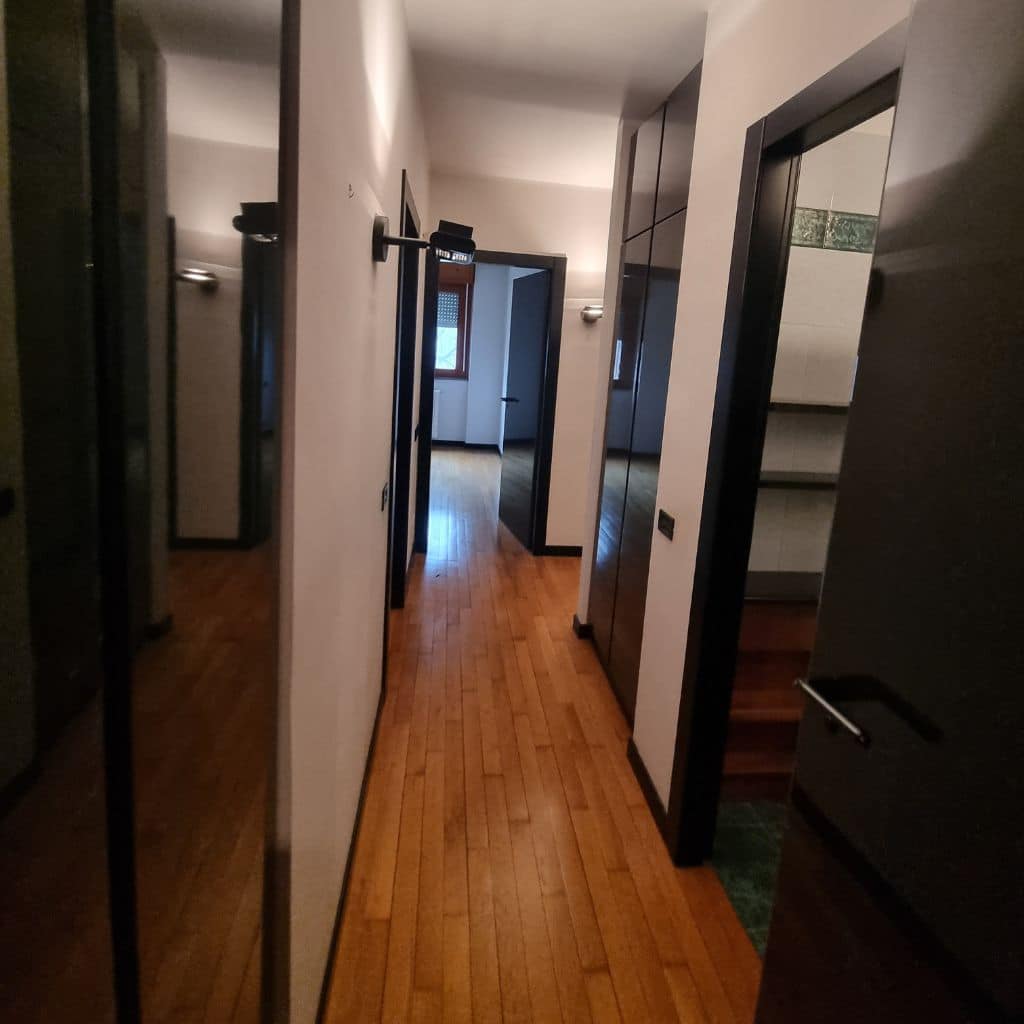Disimpegno prima (parquet, armadi neri, illuminazione a parete)