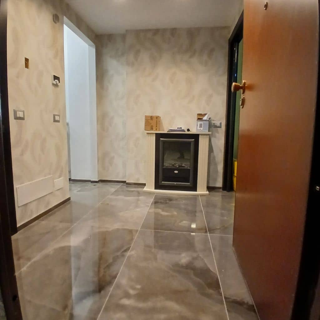 Ingresso dopo la ristrutturazione con gres effetto marmo e boiserie moderna a Milano Lorenteggio