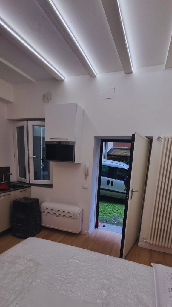 Ingresso del monolocale di 20 mq con affaccio sul cortile condominiale, illuminazione a LED integrata nel soffitto e impianti completamente rinnovati.