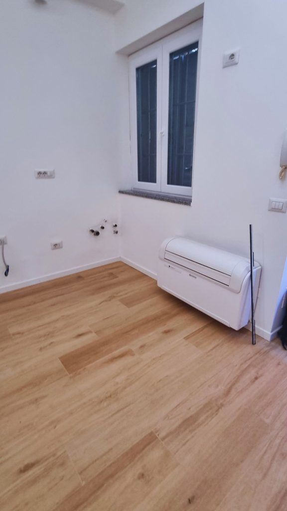 Monolocale 20 mq Milano Isola dopo ristrutturazione, arredamento zona notte con letto matrimoniale e accesso diretto al bagno.