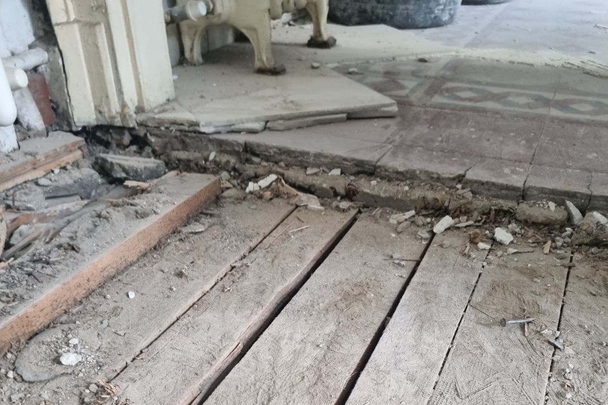 Primo piano del solaio in legno di una casa d'epoca a Milano, visibile dopo la demolizione del vecchio pavimento e massetto durante una ristrutturazione.