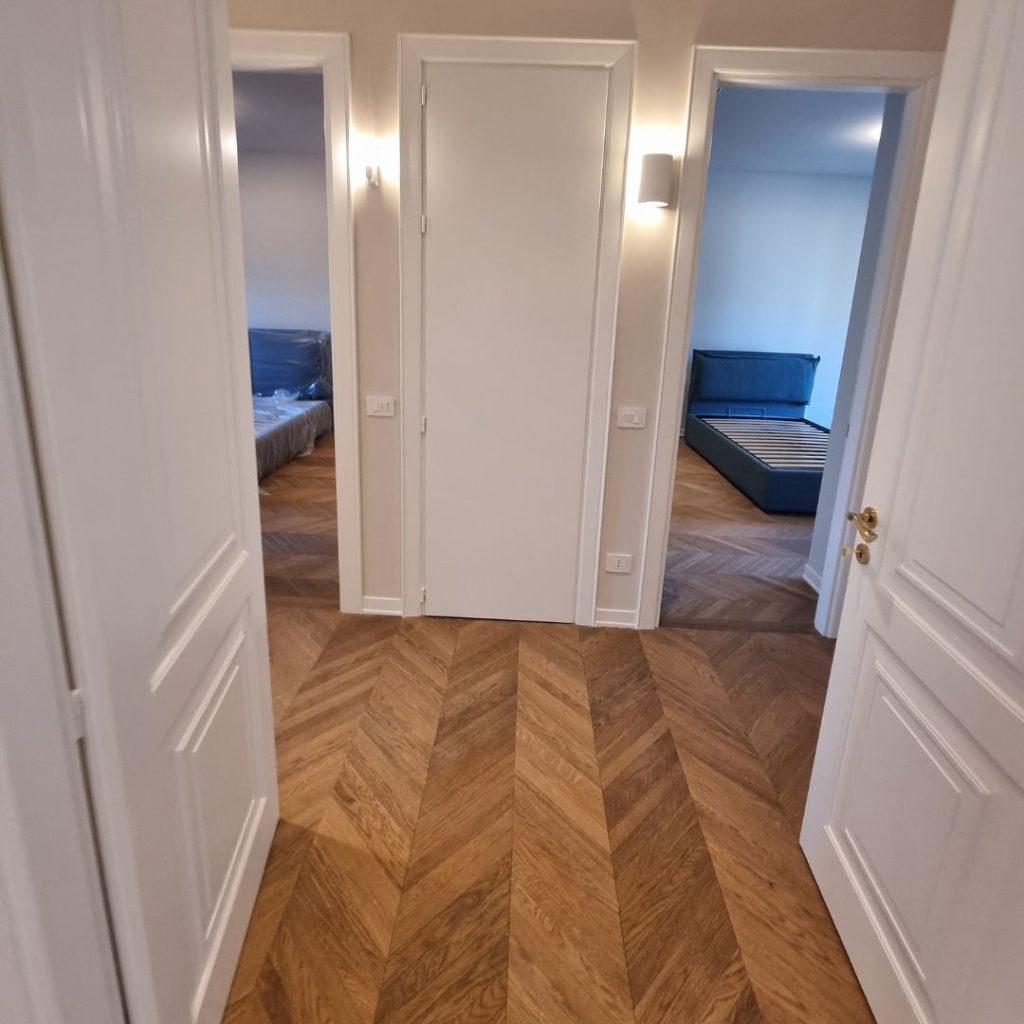 Ingresso ristrutturato con parquet a spina ungherese e porte filo-muro – appartamento 120 mq Cenisio Milano