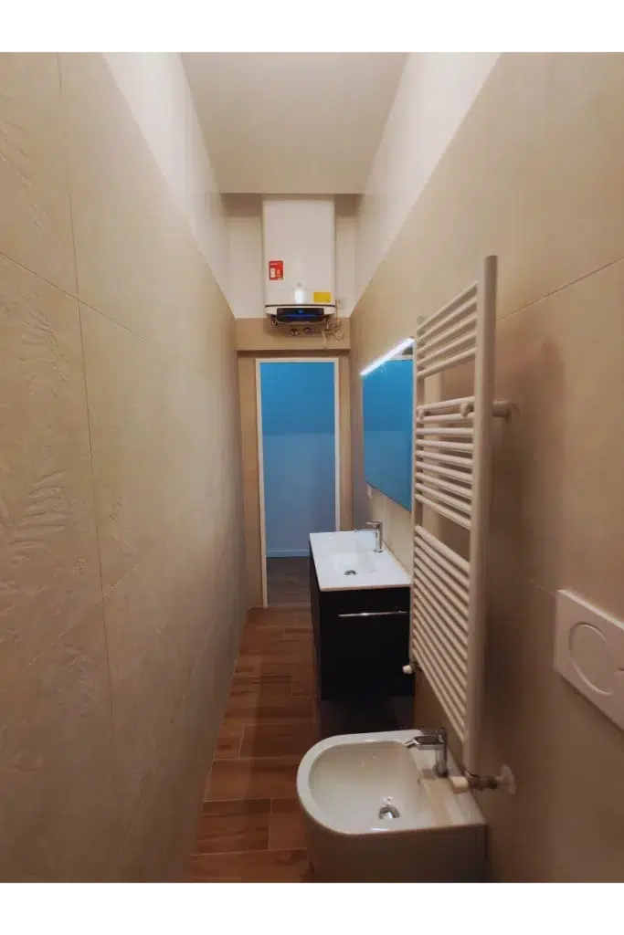 Bagno dopo – boiler elettrico bianco installato sopra la porta, trilocale 60 mq, Bacone Morgagni