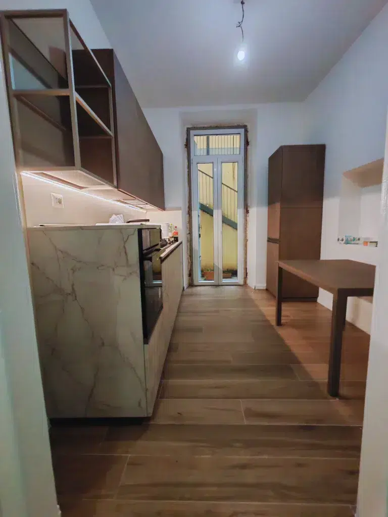 Cucina dopo – basi marmoree e pensili scuri con LED, trilocale 60 mq, Bacone Morgagni