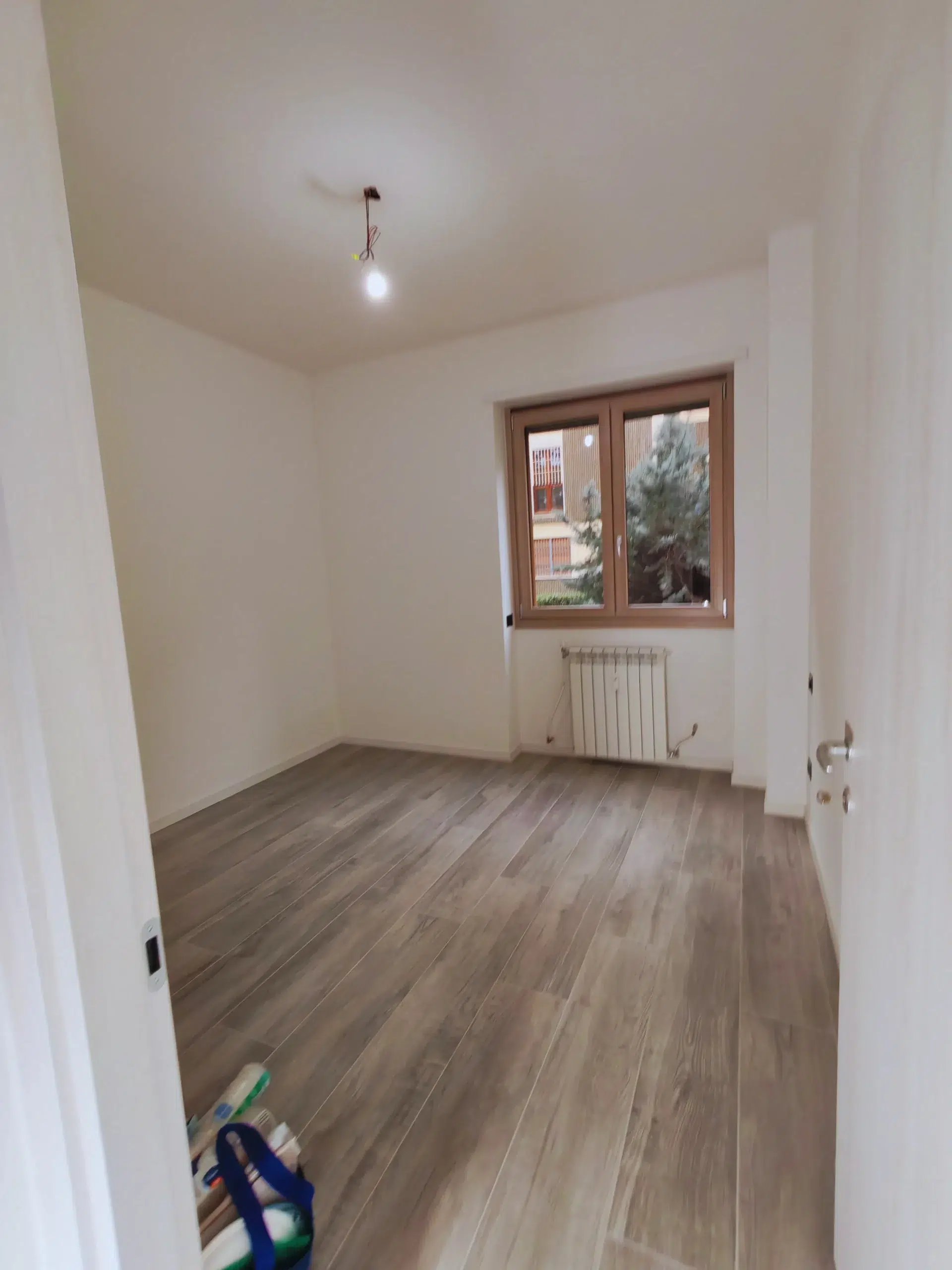 Muffa in casa e ponte termico: come eliminarla davvero (guida 2026) 3 Stessa camera ristrutturata vista dal pavimento dopo picozzatura, rasatura e pittura termoisolante — trilocale Bruzzano Milano