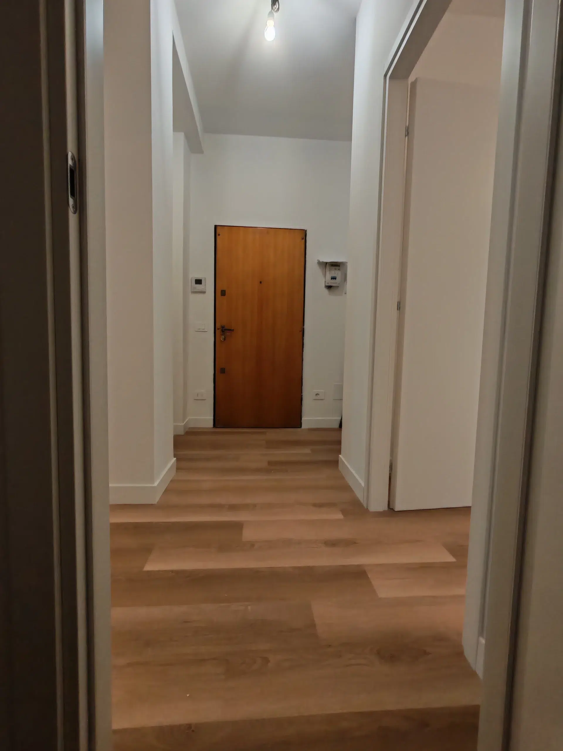 General Contractor: chi è, cosa fa e quando conviene sceglierlo 4 Vista sull’ingresso del bilocale ristrutturato con nuova distribuzione degli spazi, pavimento effetto legno e porte interne bianche, Milano Martesana