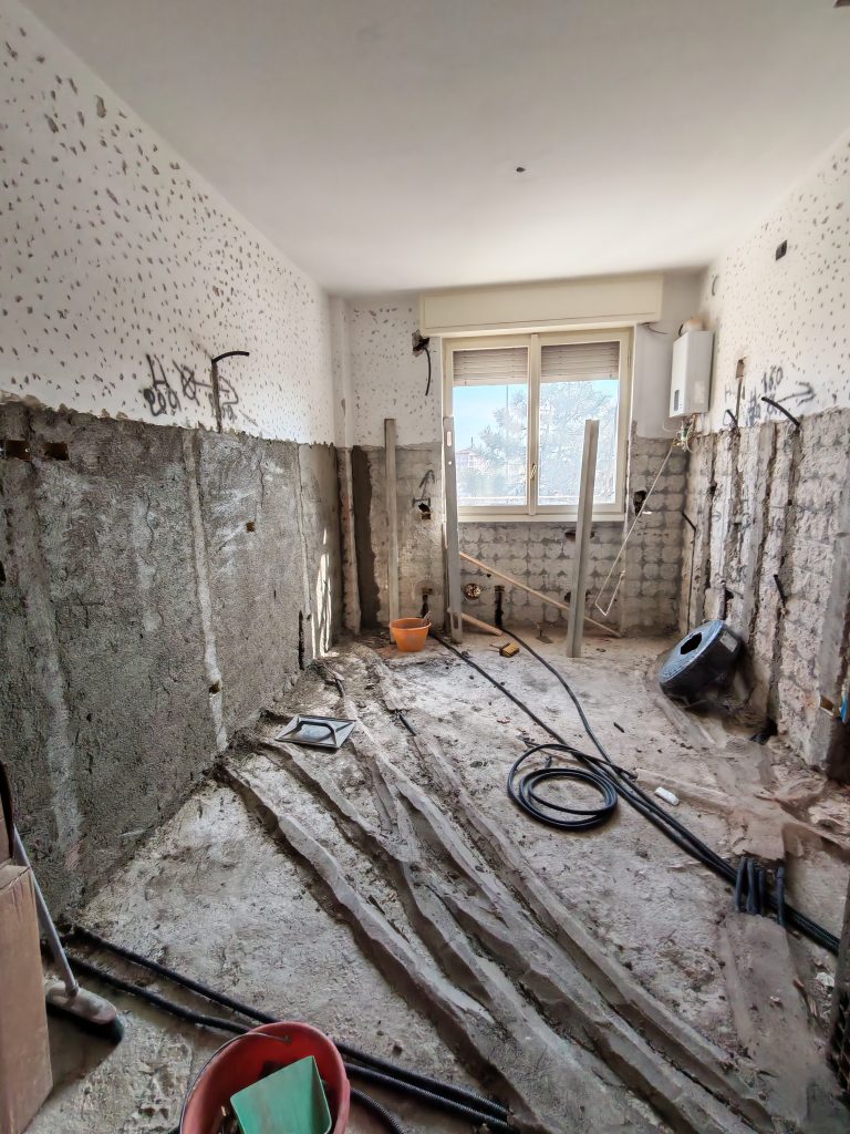 Stanza con massetto rimosso e tracce degli impianti termoidraulici prima del nuovo getto