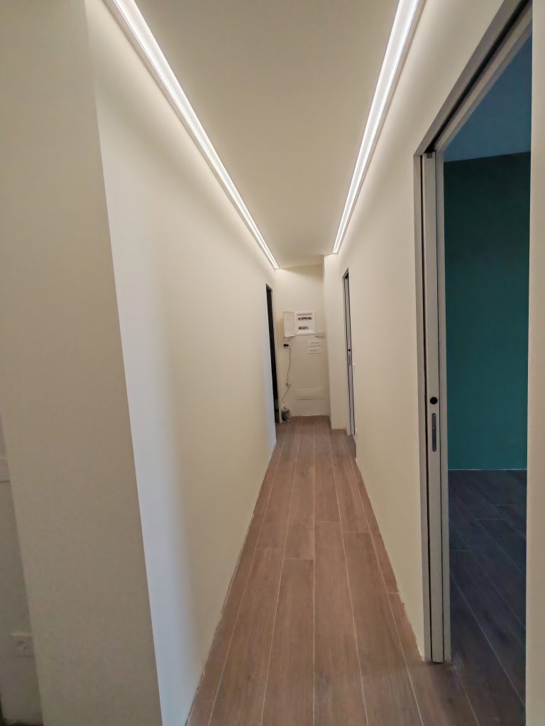 corridoio dopo ristrutturazione lungo led parete verde in fondo appartamento 112mq brenta milano