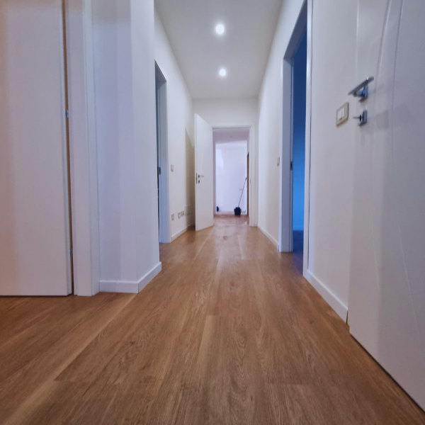 garibaldi-appartamento-100mq-dopo-corridoio-prospettiva-bassa-con-pavimento-effetto-legno-continuo Corridoio dopo – prospettiva bassa con pavimento effetto legno continuo e faretti incassati, appartamento 100 mq, Garibaldi